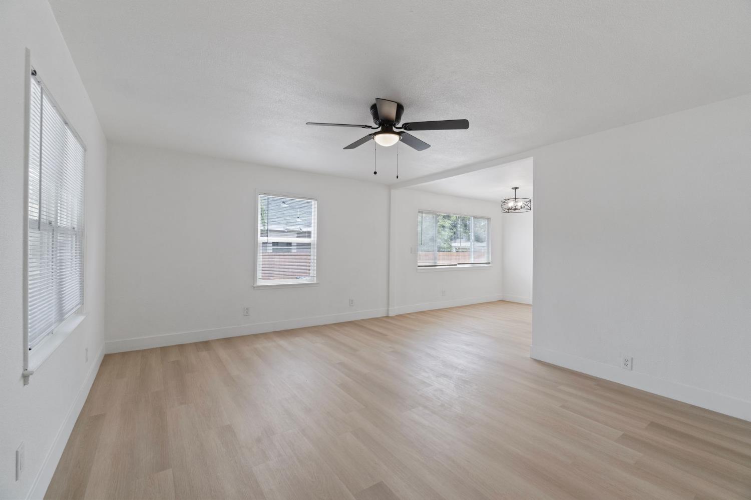 1559 North Carruth Avenue Fresno, CA 93728 - Photo 5 of 24 a view of an empty room with a window and wooden floor