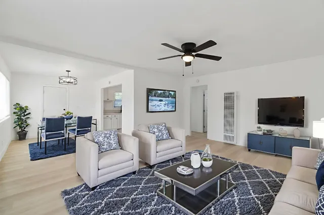 a living room with furniture a rug and a flat screen tv