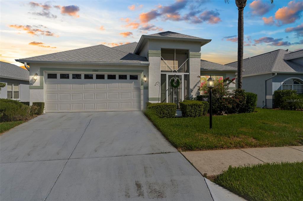 11847 Spindrift Loop Hudson, FL 34667 - Photo 1 of 28 a front view of a house with a yard and trees