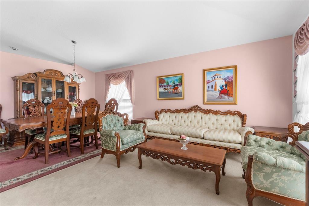 11847 Spindrift Loop Hudson, FL 34667 - Photo 5 of 28 a living room with furniture a piano and a chandelier
