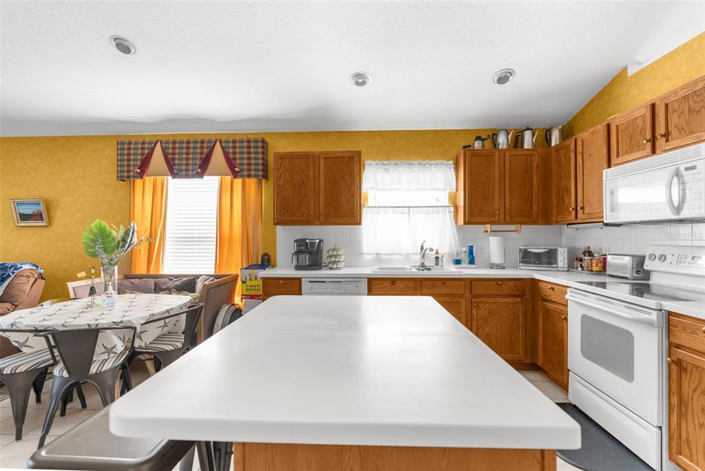 11847 Spindrift Loop Hudson, FL 34667 - Photo 10 of 28 a large kitchen with kitchen island a large window in it