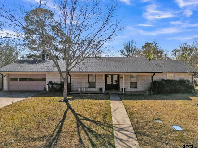 a front view of house with yard space and trees