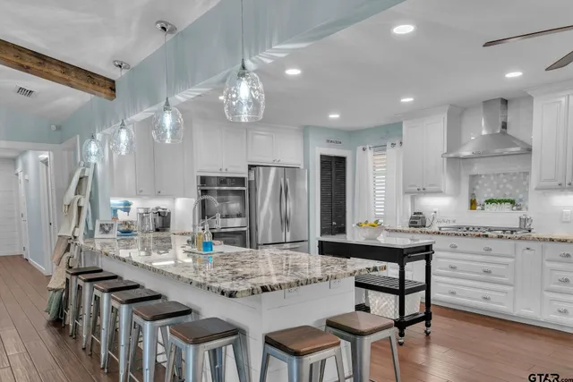 a kitchen with kitchen island granite countertop a table and chairs in it