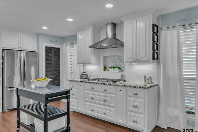 a kitchen with kitchen island granite countertop a sink stove and refrigerator
