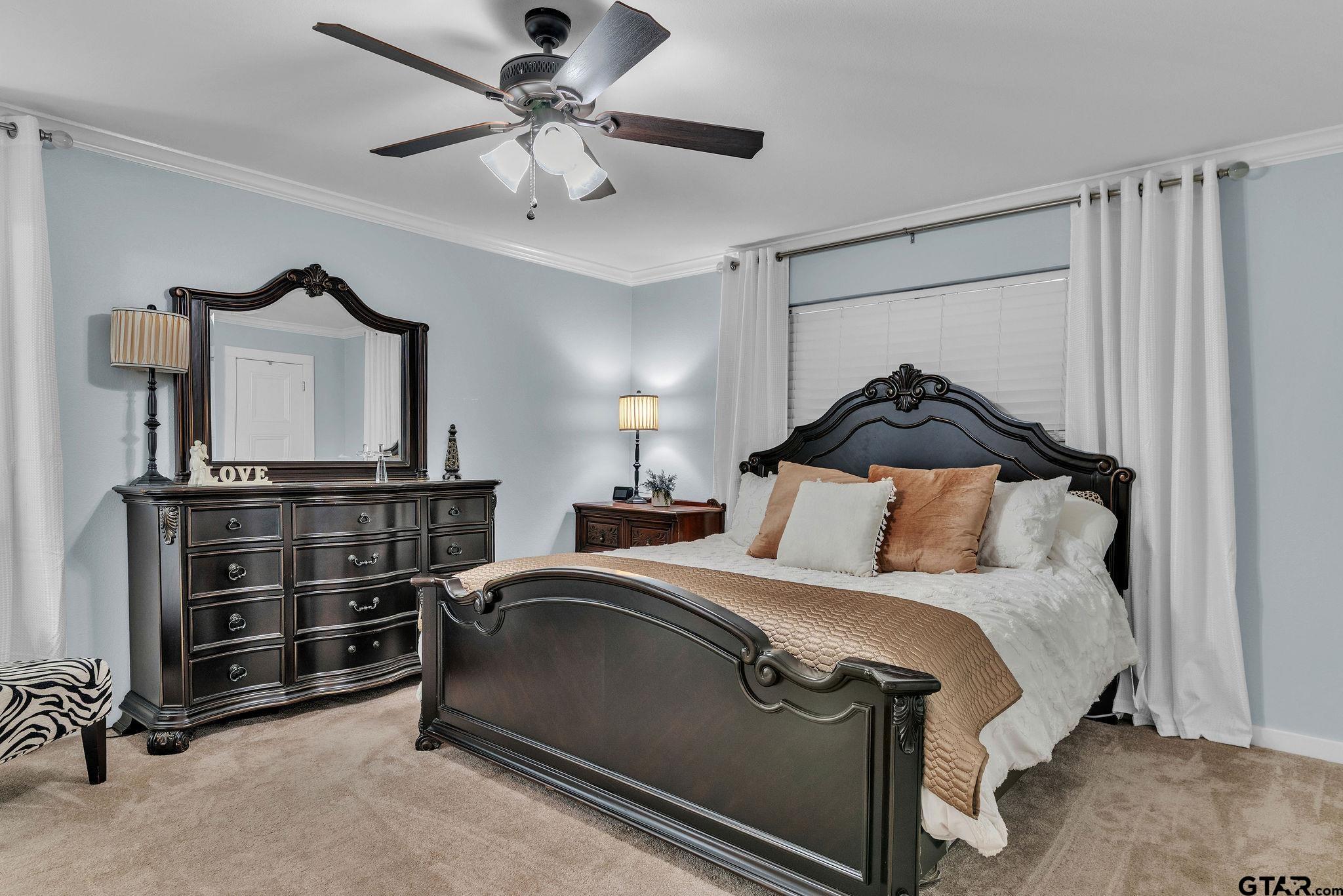 1208 Briarwood Lane Longview, TX 75604 - Photo 18 of 43 a bedroom with a bed and a chandelier