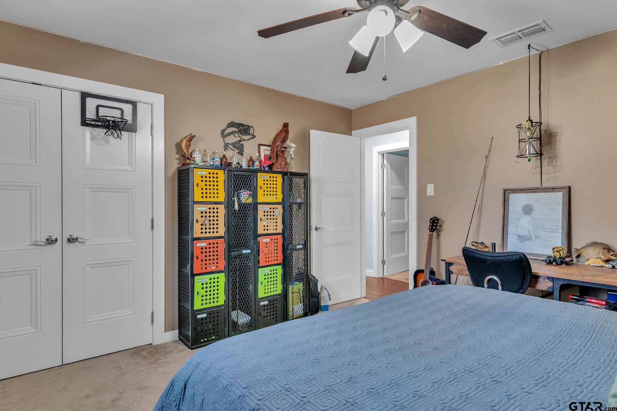 1208 Briarwood Lane Longview, TX 75604 - Photo 28 of 43 a bedroom with a bed and a chandelier