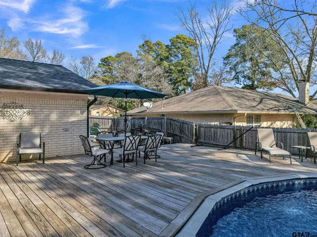 a view of a patio with table and chairs under an umbrella with wooden floor