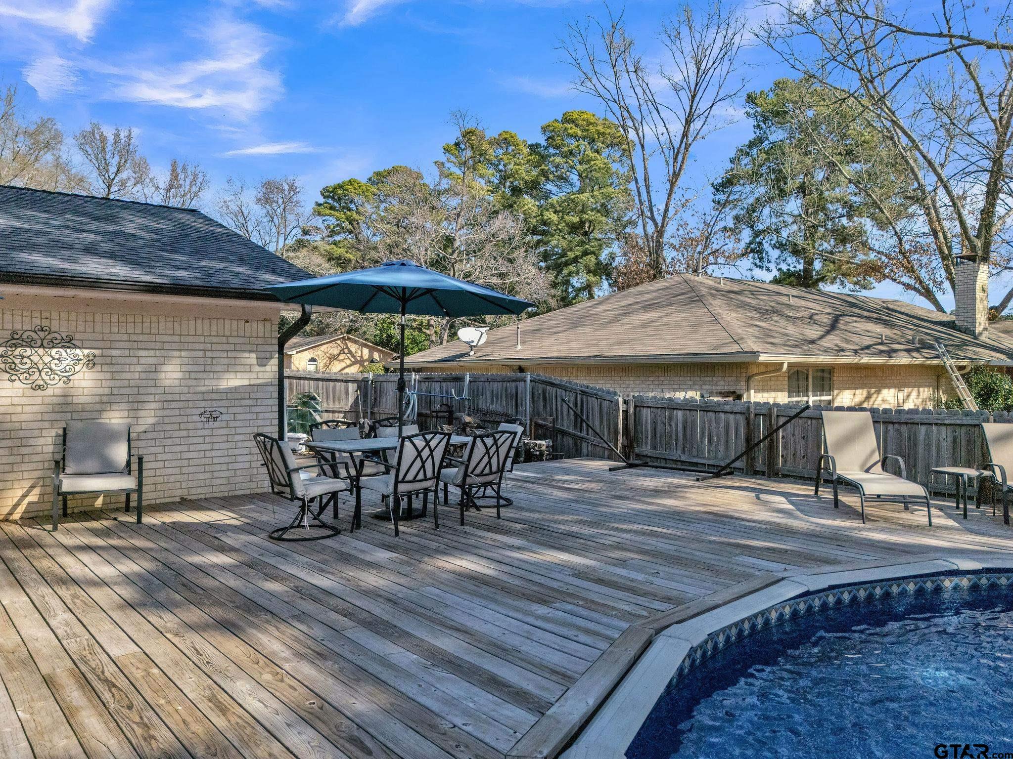 1208 Briarwood Lane Longview, TX 75604 - Photo 33 of 43 a view of a roof deck with table and chairs under an umbrella with wooden floor