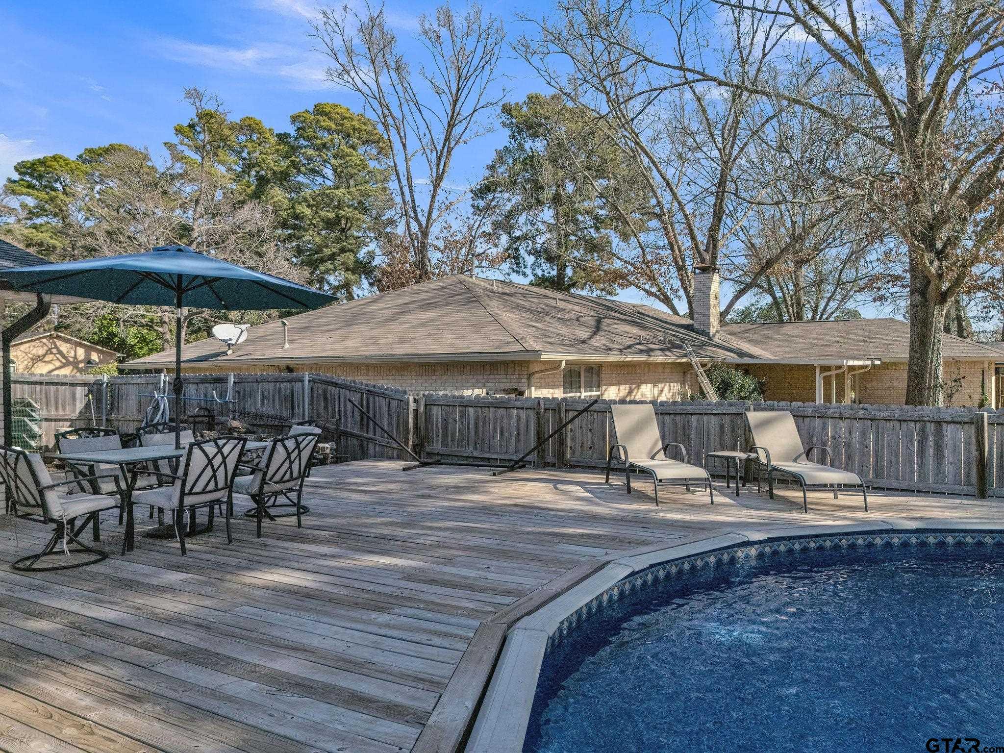 1208 Briarwood Lane Longview, TX 75604 - Photo 34 of 43 a view of a patio with table and chairs under an umbrella with wooden floor