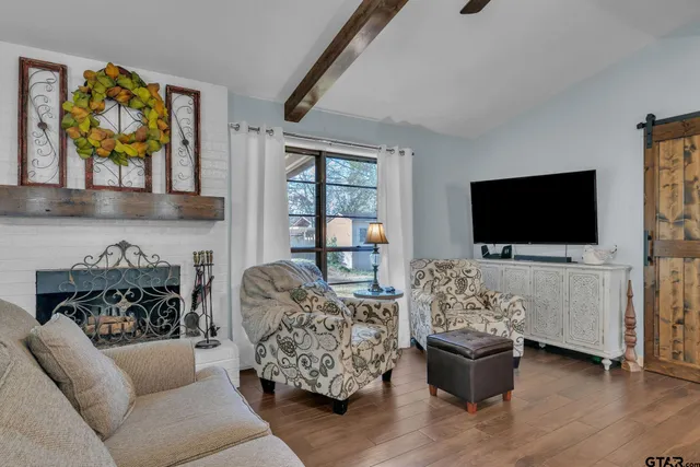 a living room with furniture a flat screen tv and a fireplace