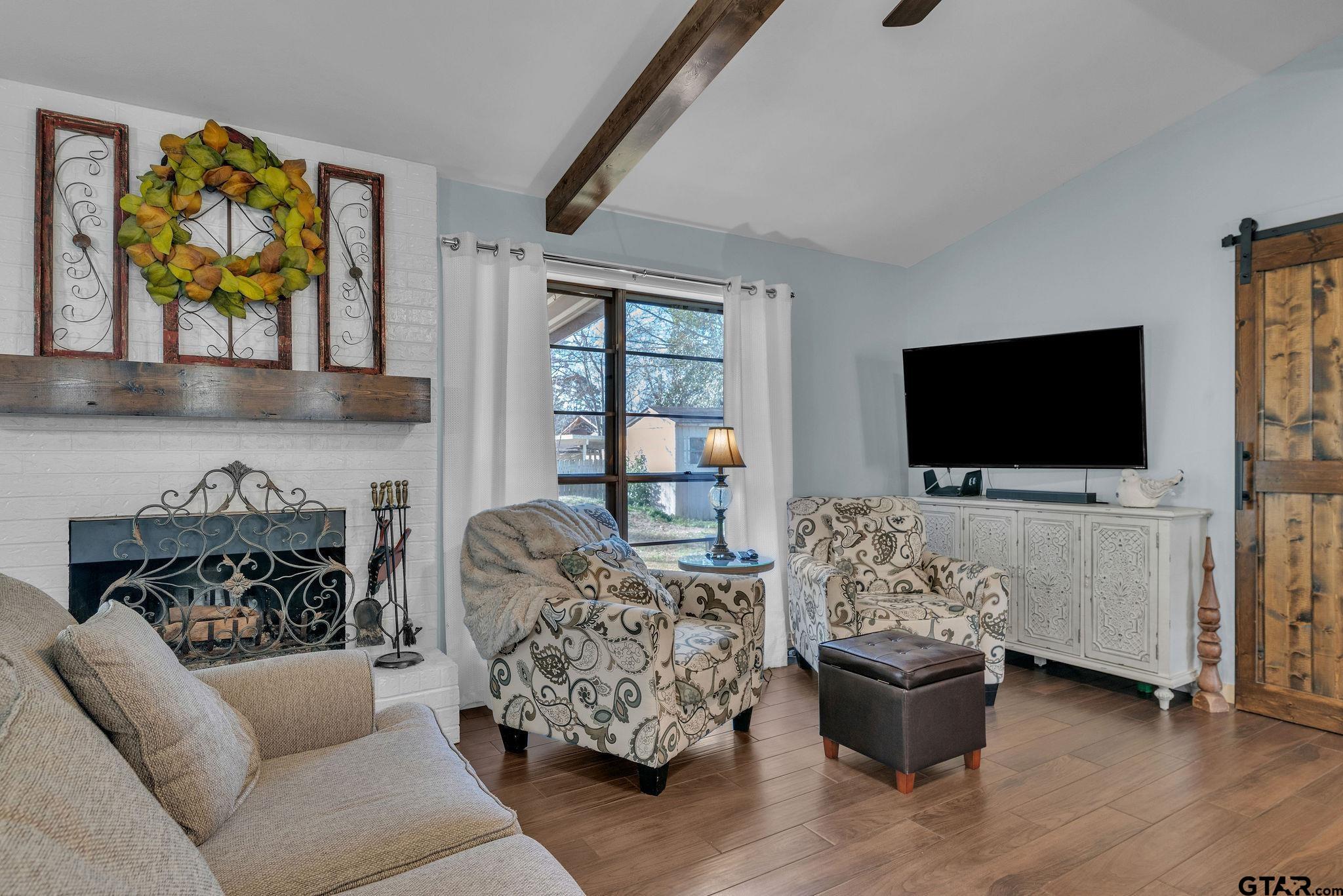 1208 Briarwood Lane Longview, TX 75604 - Photo 6 of 43 a living room with furniture a flat screen tv and a fireplace