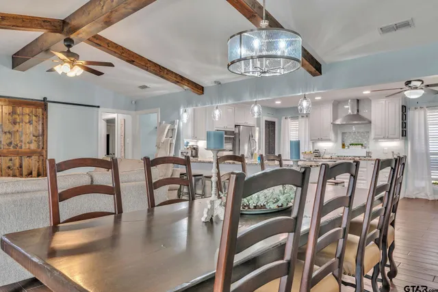 a dining room with furniture a chandelier and wooden floor