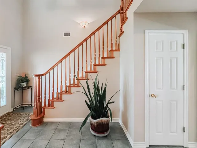 a view of a hallway with wooden floor and staircase