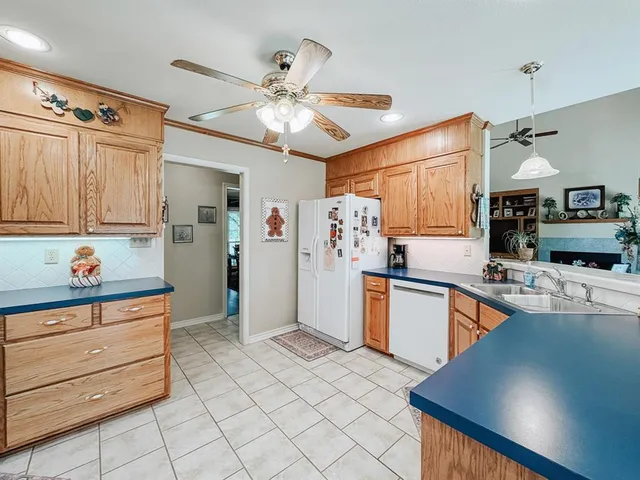 a kitchen with stainless steel appliances kitchen island granite countertop a refrigerator and a stove top oven
