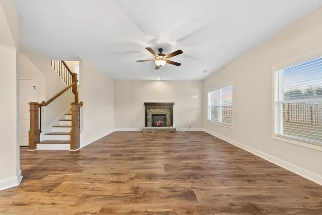 a view of a livingroom with a fireplace a chandelier and wooden floor