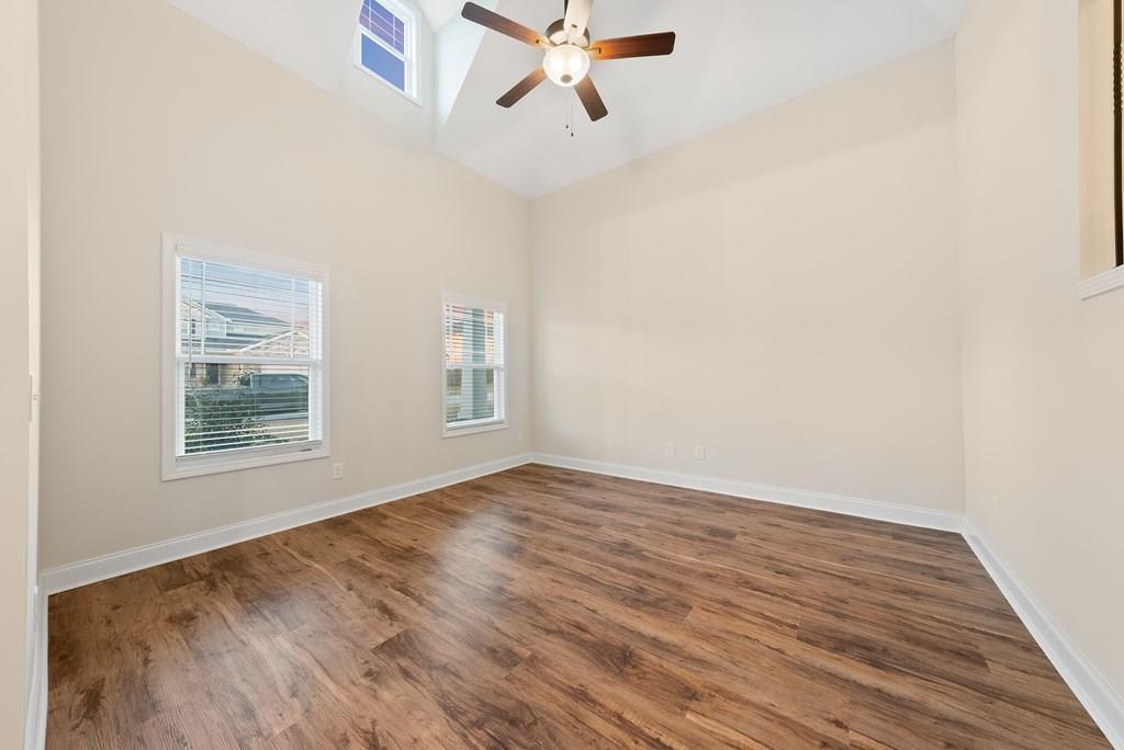 7312 Pine Chase Drive Midland, GA 31820 - Photo 20 of 51 an empty room with wooden floor ceiling fan and windows
