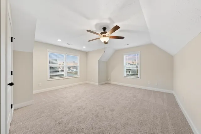 an empty room with a window and ceiling fan