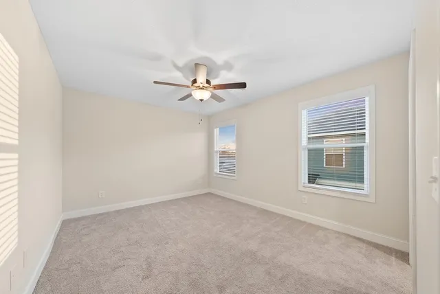 a view of a room with a ceiling fan and a window