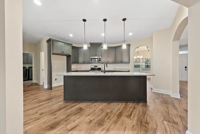 a kitchen with kitchen island stainless steel appliances a sink refrigerator and microwave