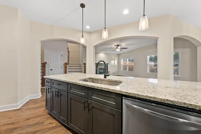 a kitchen with a sink and a wooden floor