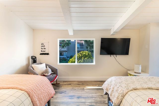 a bedroom with a bed tv and window