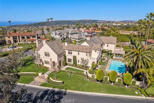 an aerial view of a house with a swimming pool and a yard