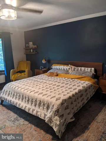 a bed sitting in a bedroom next to a window