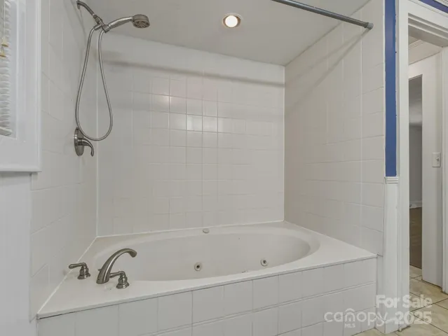 a bathroom with a bath tub with a shower