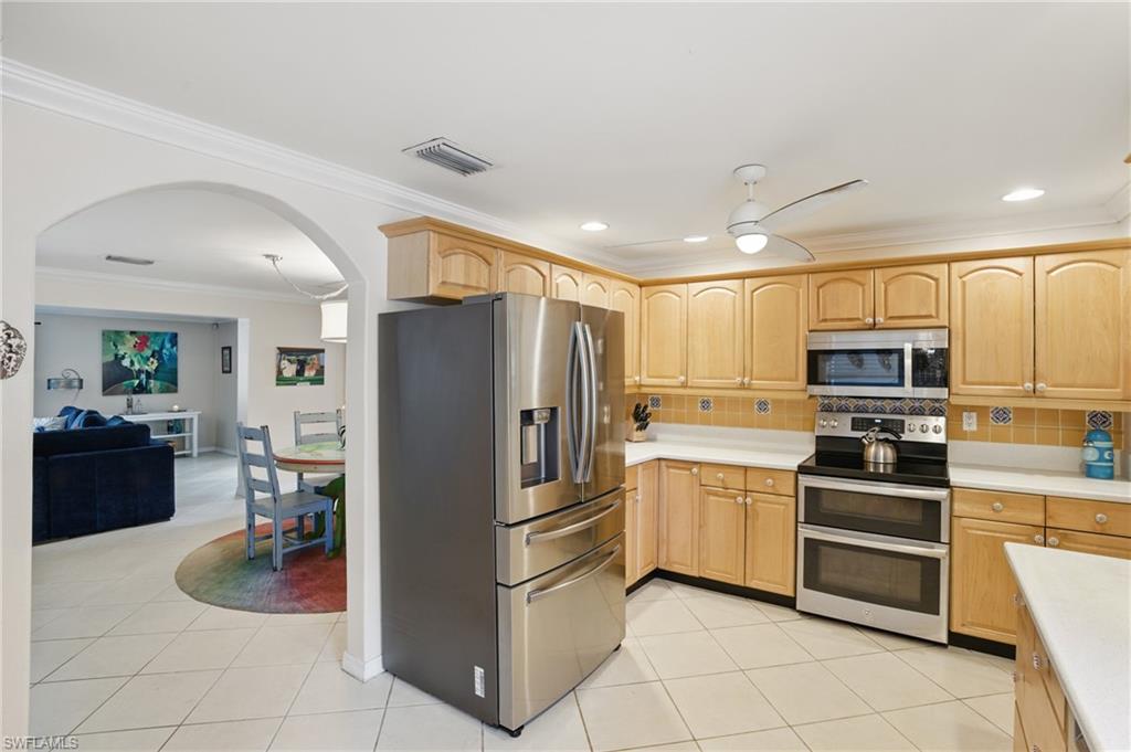 261 Viking Way Naples, FL 34110 - Photo 14 of 40 a kitchen with stainless steel appliances granite countertop a refrigerator and a stove top oven