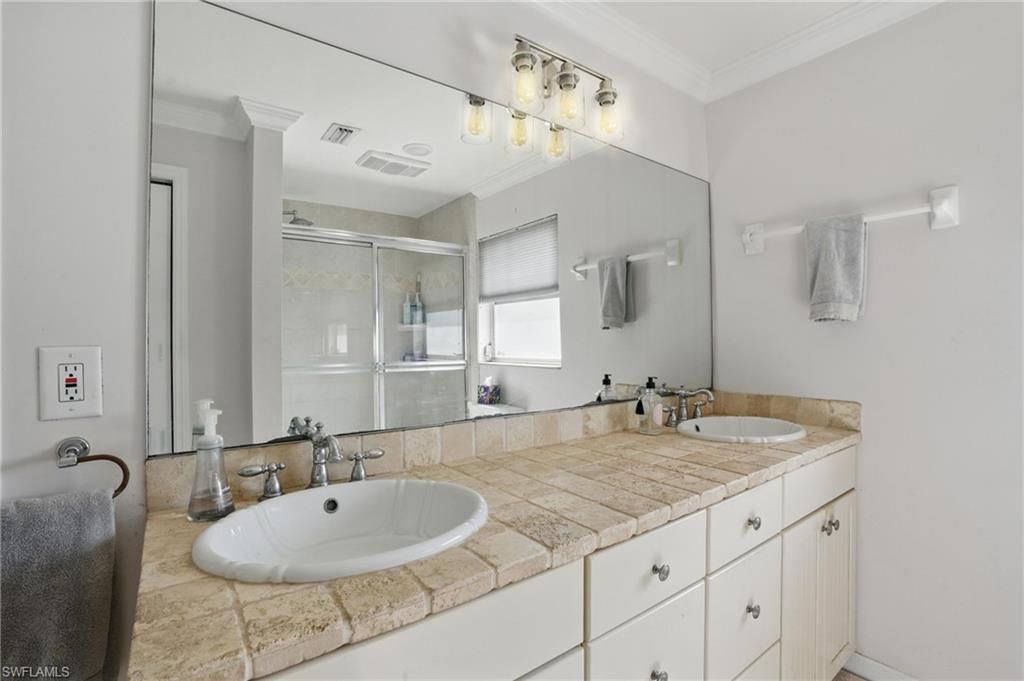 261 Viking Way Naples, FL 34110 - Photo 19 of 40 a bathroom with a granite countertop sink a mirror and shower