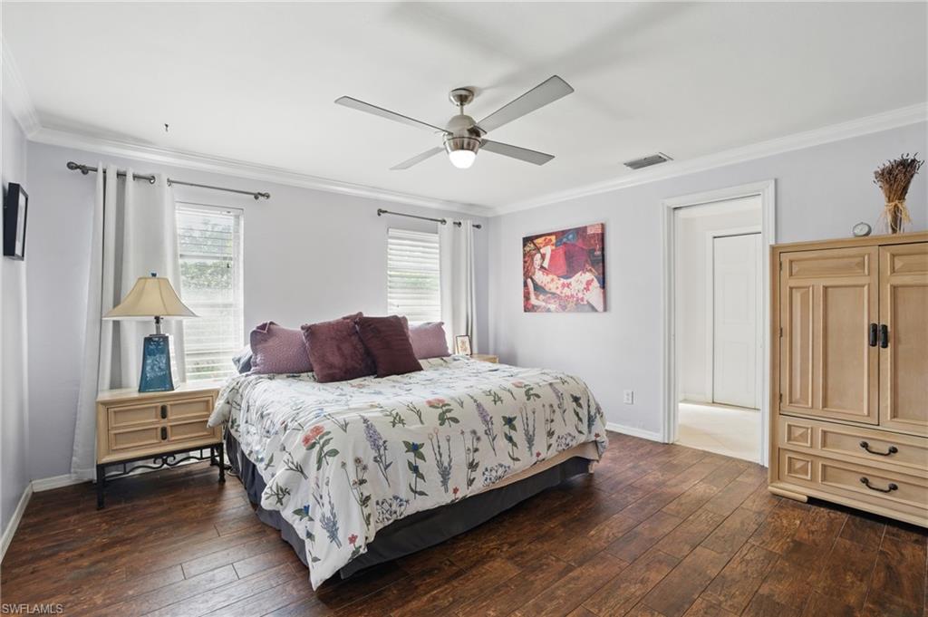 261 Viking Way Naples, FL 34110 - Photo 23 of 40 a bedroom with a bed and dresser with wooden floor
