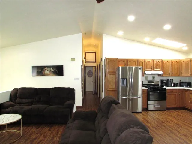 a living room with furniture a refrigerator and kitchen view