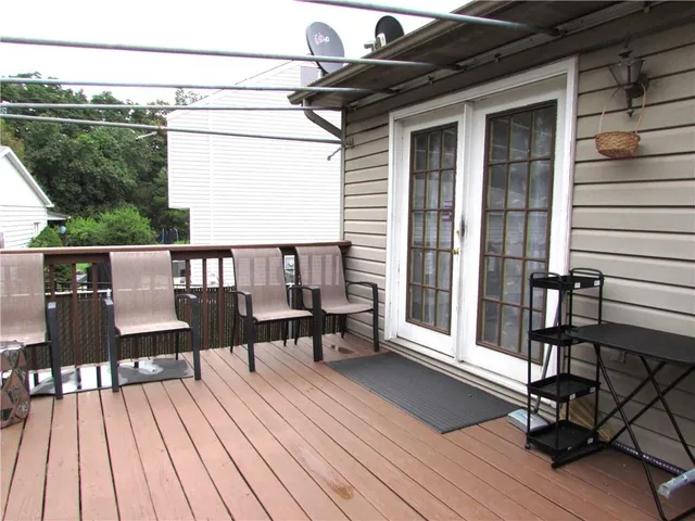 a view of a balcony with chairs and wooden floor