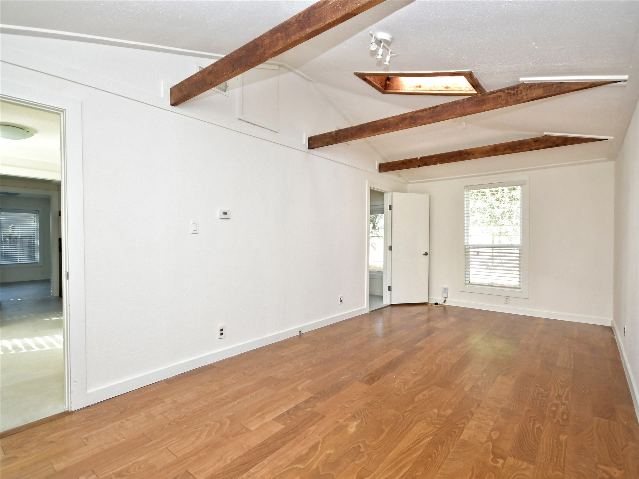 4604 Red River Street, Unit B Austin, TX 78751 - Photo 4 of 15 Warm wood flooring extends throughout this generous living space, accented by exposed beam vaulted ceilings and a skylight.