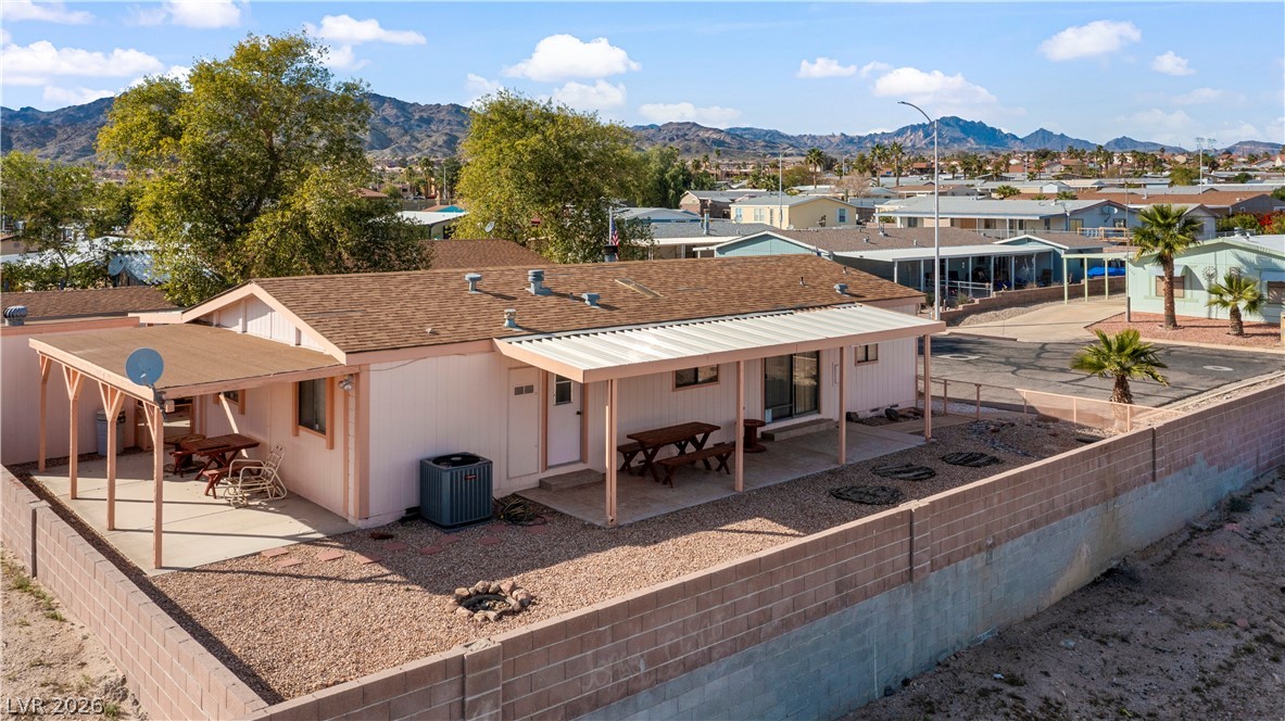 1609 Cajon Court Laughlin, NV 89029 - Photo 62 of 69 Rear view of house featuring a patio, a mountain view, a fenced backyard, roof with shingles, and a residential view