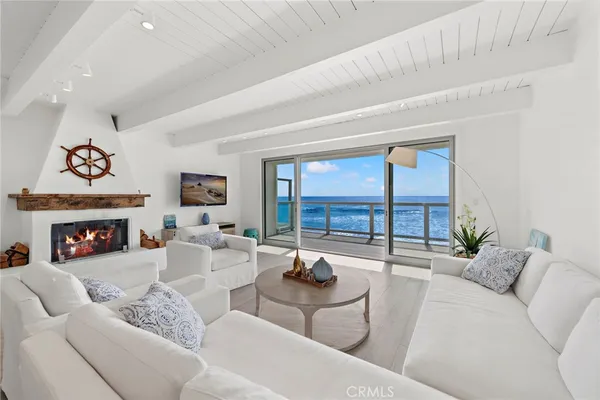 a living room with furniture a fireplace and a floor to ceiling window