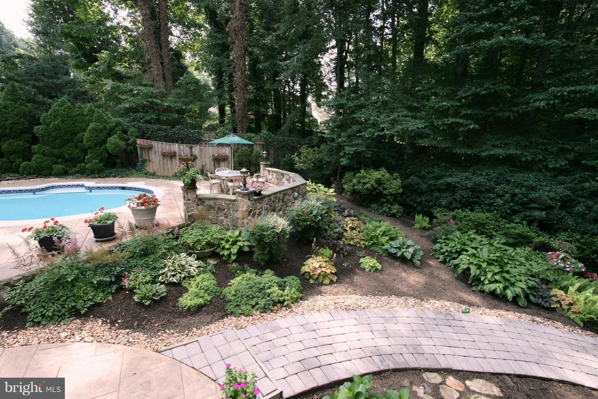 11939 Riders Lane Reston, VA 20191 - Photo 27 of 30 a view of a garden with lawn chairs under an umbrella