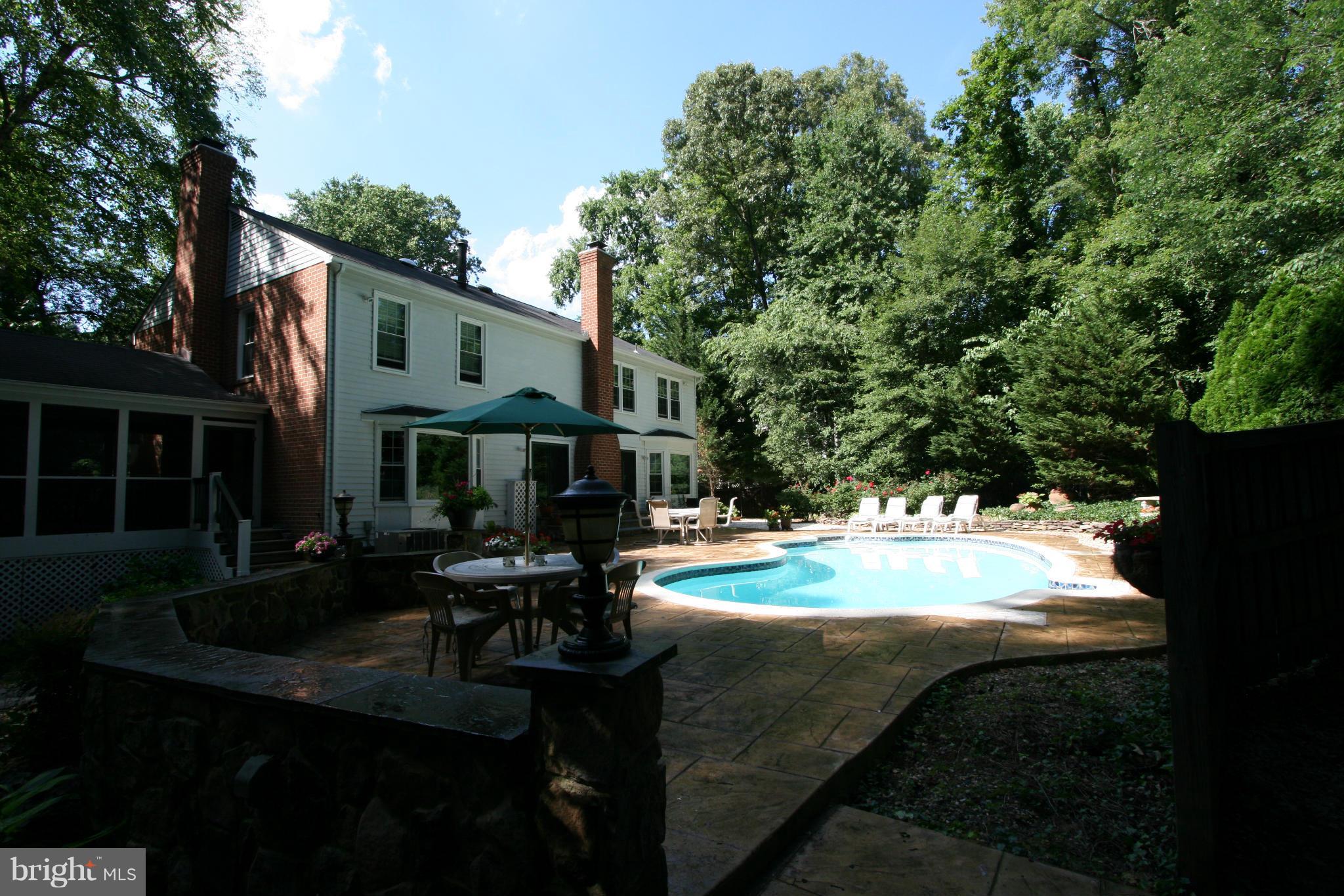 11939 Riders Lane Reston, VA 20191 - Photo 28 of 30 a view of patio with table and chairs and potted plants with large tree