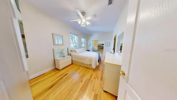 a bedroom with a bed and wooden floor
