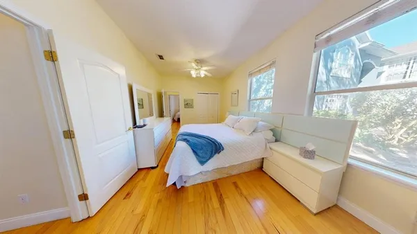 a bedroom with a bed and wooden floor