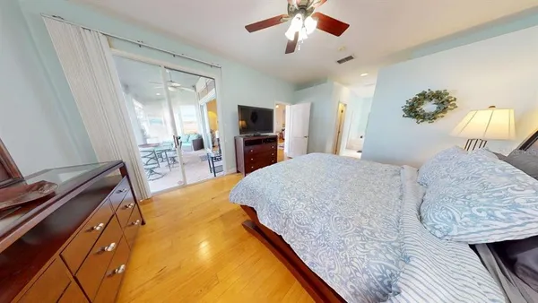 a bedroom with a bed and a flat tv screen on dresser