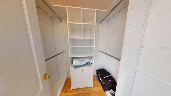 a view of walk in closet with empty racks