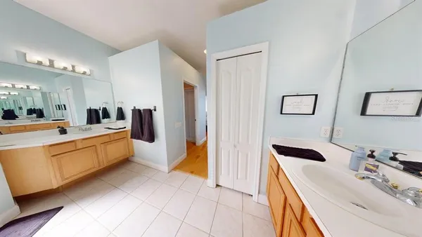 a large white bathroom with a double vanity sink a mirror and a shower