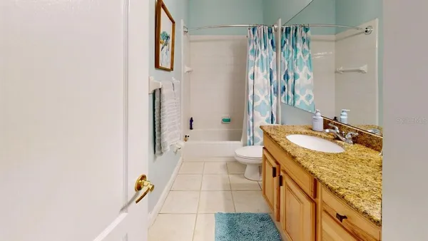 a bathroom with a granite countertop sink a mirror and shower