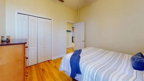 a bedroom with a bed and wooden floor