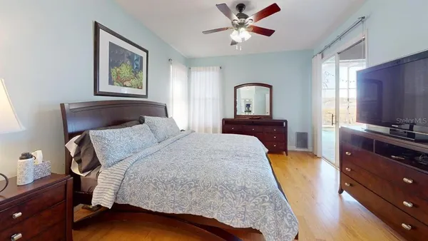 a bedroom with a bed and wooden floor