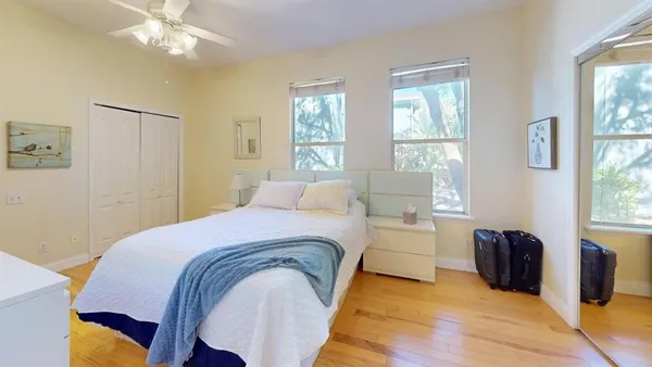 a spacious bedroom with a bed and wooden floor