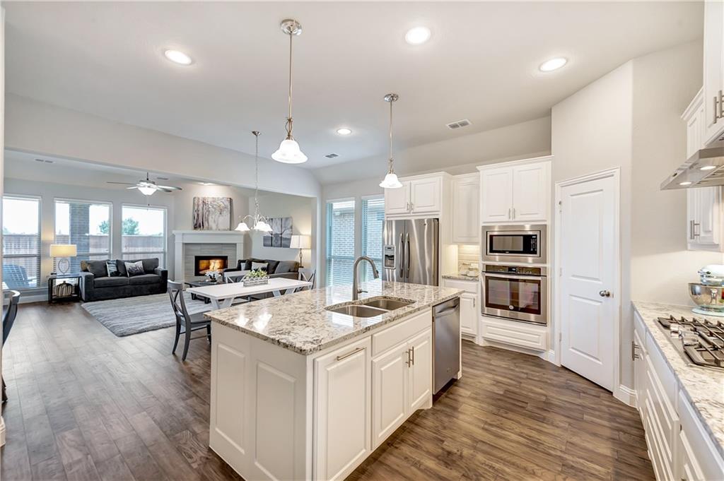 a large kitchen with kitchen island a large counter space a sink stainless steel appliances and cabinets