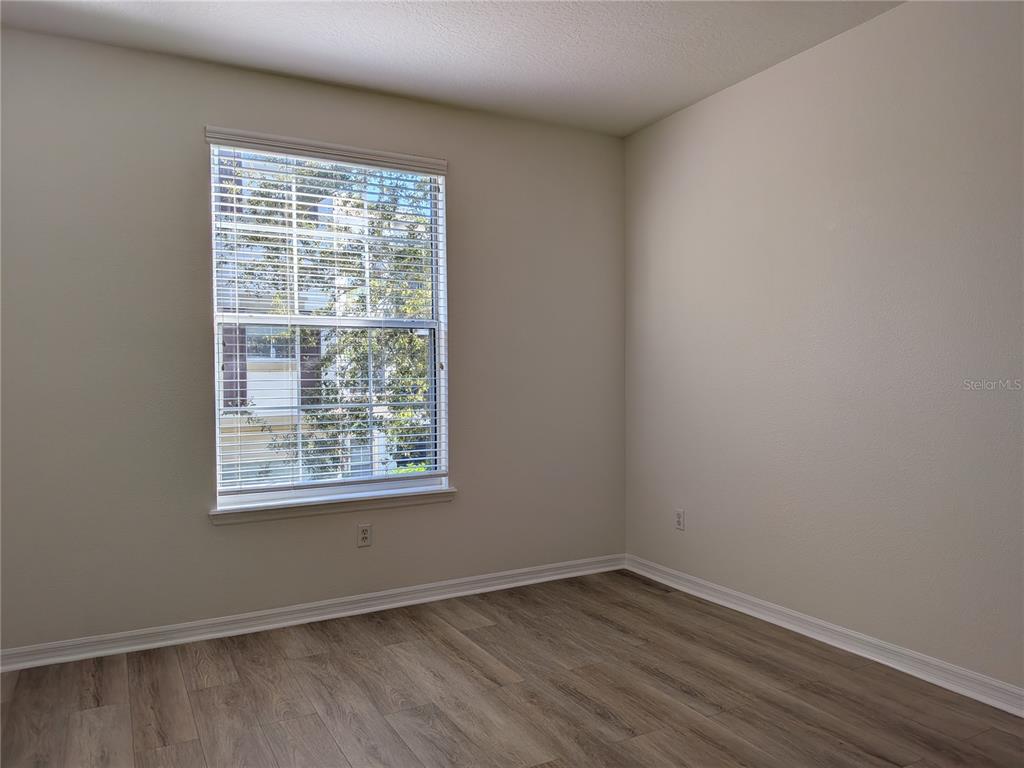 11562 Amidship Lane, Unit 208 Windermere, FL 34786 - Photo 16 of 31 a view of an empty room with wooden floor and a window