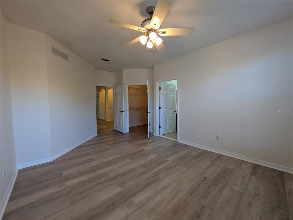11562 Amidship Lane, Unit 208 Windermere, FL 34786 - Photo 24 of 31 a view of an empty room with chandelier fan and wooden floor